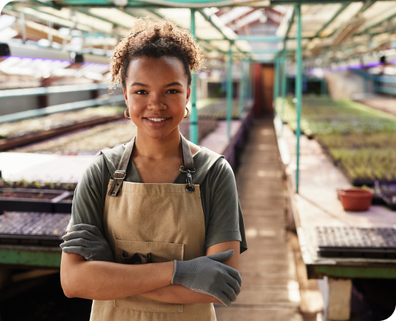 Greenhouse owner standing in front of rows of plants