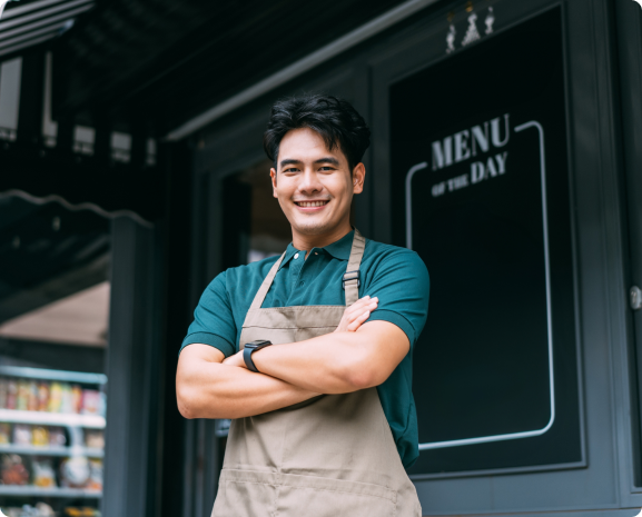 Business owner standing in front of menu board